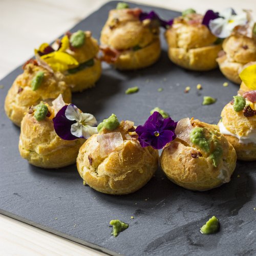 Beignets mit Erbsencreme, Burratakäse und knusprigem Speck aus Piacenza